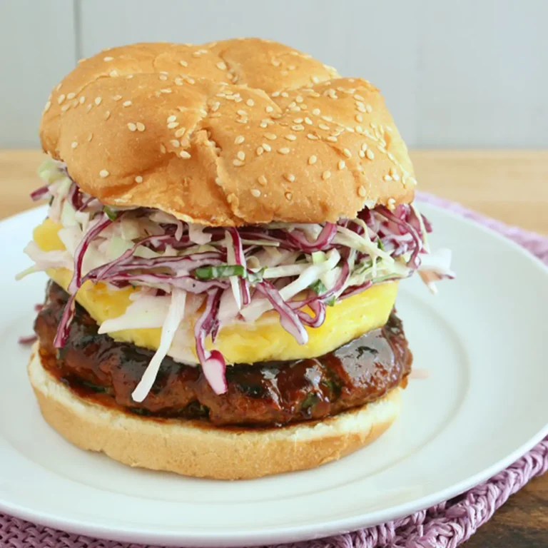 2:13 PMClaude responded: A BBQ sausage burger on a toasted sesame seed bun stacked with a Jones All Natural Pork Sausage Roll patty basted in hickory BBQ sauce, a fresh pineapple slice…A BBQ sausage burger on a toasted sesame seed bun stacked with a Jones All Natural Pork Sausage Roll patty basted in hickory BBQ sauce, a fresh pineapple slice, and basil lime red and white cabbage slaw, served on a white plate.