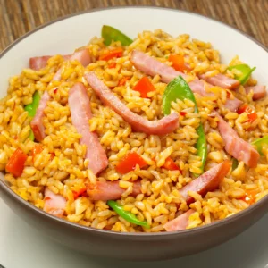 A bowl of ham and vegetable fried rice with strips of Jones Breakfast Ham, red bell pepper, and snow peas tossed in a tamari and rice vinegar sauce.
