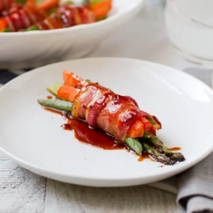 11:19 AMClaude responded: A single Jones bacon-wrapped bundle of asparagus, carrots, and green beans glazed with soy honey sauce, plated on a white dish with a serving bowl of additiona…A single Jones bacon-wrapped bundle of asparagus, carrots, and green beans glazed with soy honey sauce, plated on a white dish with a serving bowl of additional bundles in the background.
