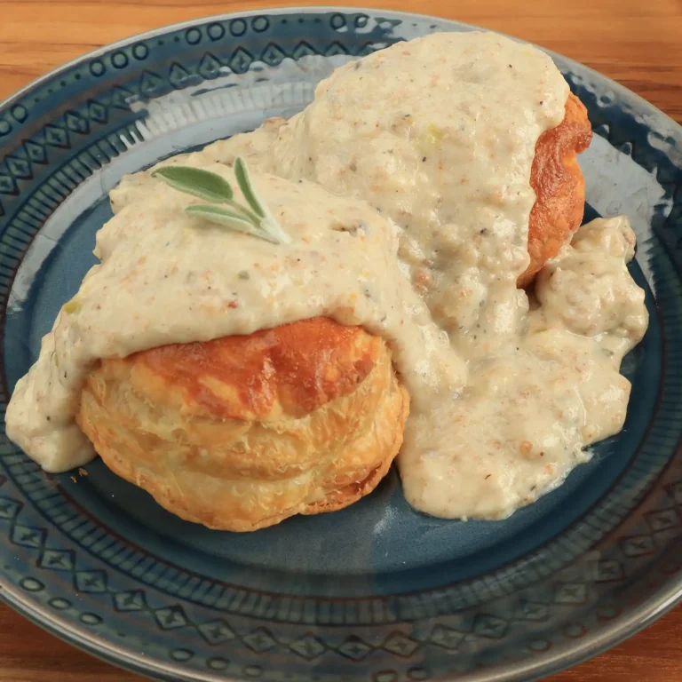 10:51 AMClaude responded: Two golden flaky biscuits smothered in creamy Jones Scrapple gravy, garnished with a fresh sage sprig, served on a blue ceramic plate.Two golden flaky biscuits smothered in creamy Jones Scrapple gravy, garnished with a fresh sage sprig, served on a blue ceramic plate.