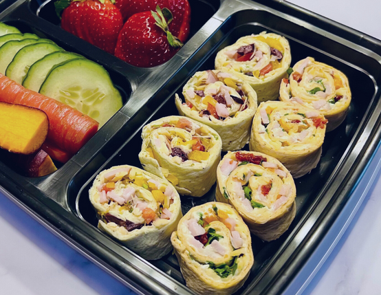 Mediterranean Pinwheels with Canadian Bacon in a Bento Box with fruits and veggies