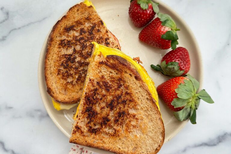 Toasted breakfast sandwich with Canadian bacon and strawberries on the side, canadian bacon breakfast