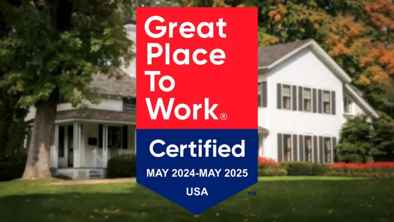 Great Place To Work Certified badge for May 2023–May 2024, USA, displayed over a blurred photo of the Jones Dairy Farm farmhouse in Fort Atkinson, Wisconsin.