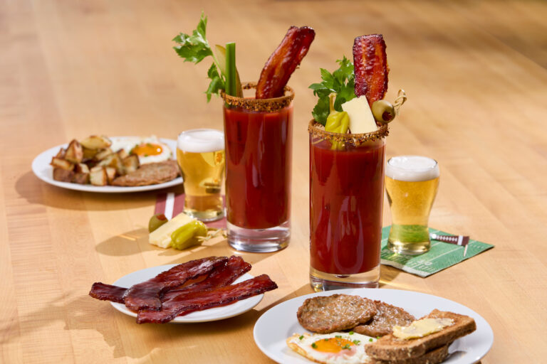 A plate of candied bacon in front of two Bloody Marys with Million Dollar Bacon, Candied Bacon, Jones Dairy Farm Dry Aged Bacon, Millionaire's Bacon, Sweet and Savory Candied Bacon, Sweet and spicy bacon, Menu ideas, Foodservice, Food Service Recipe, Bloody Mary or appetizer ideas for bacon, candied bacon recipe