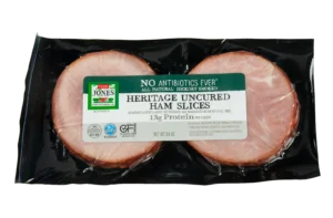 Jones Dairy Farm No Antibiotics Ever Heritage Uncured Ham Slices, 6.4 oz, all natural hickory smoked, Certified Gluten Free with no sugar, no nitrates or nitrites added, and 13g protein per 4 slices, in vacuum-sealed black packaging.