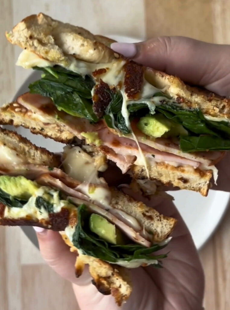 Inside-out toasted everything bagel sandwich with Canadian Bacon, spinach, avocado, and provolone.