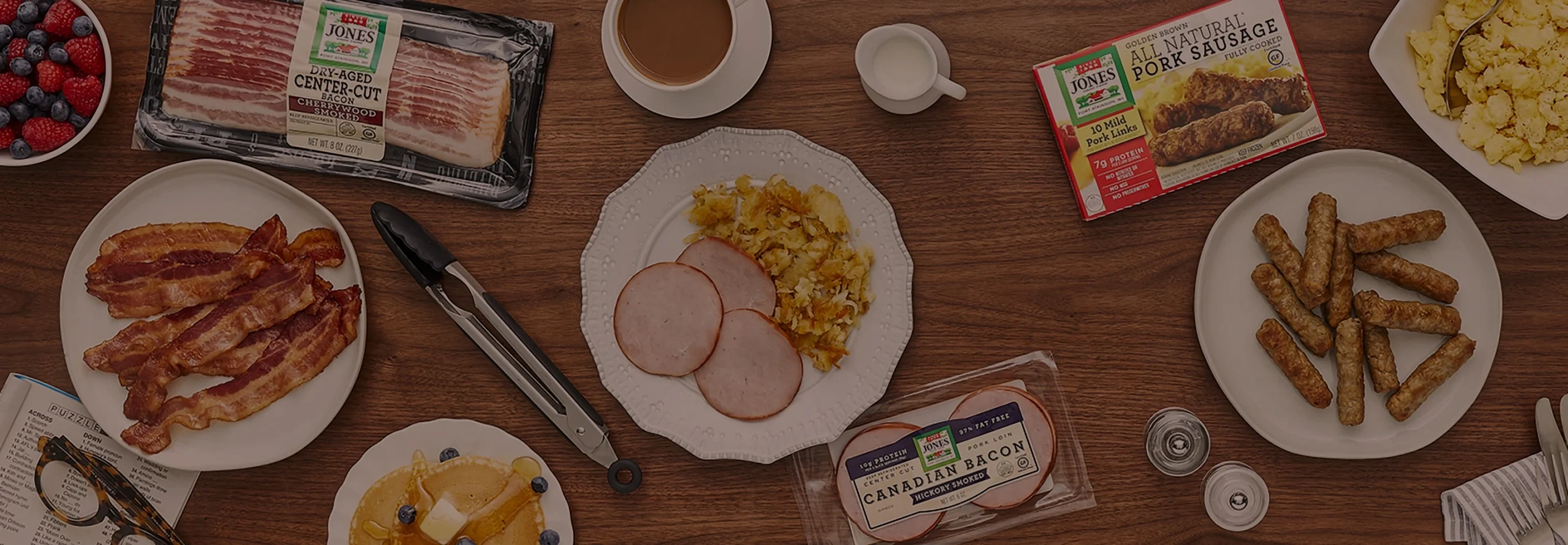 Breakfast spread with Jones bacon, sausage links, and Canadian bacon, plus pancakes, eggs, hash browns, and coffee