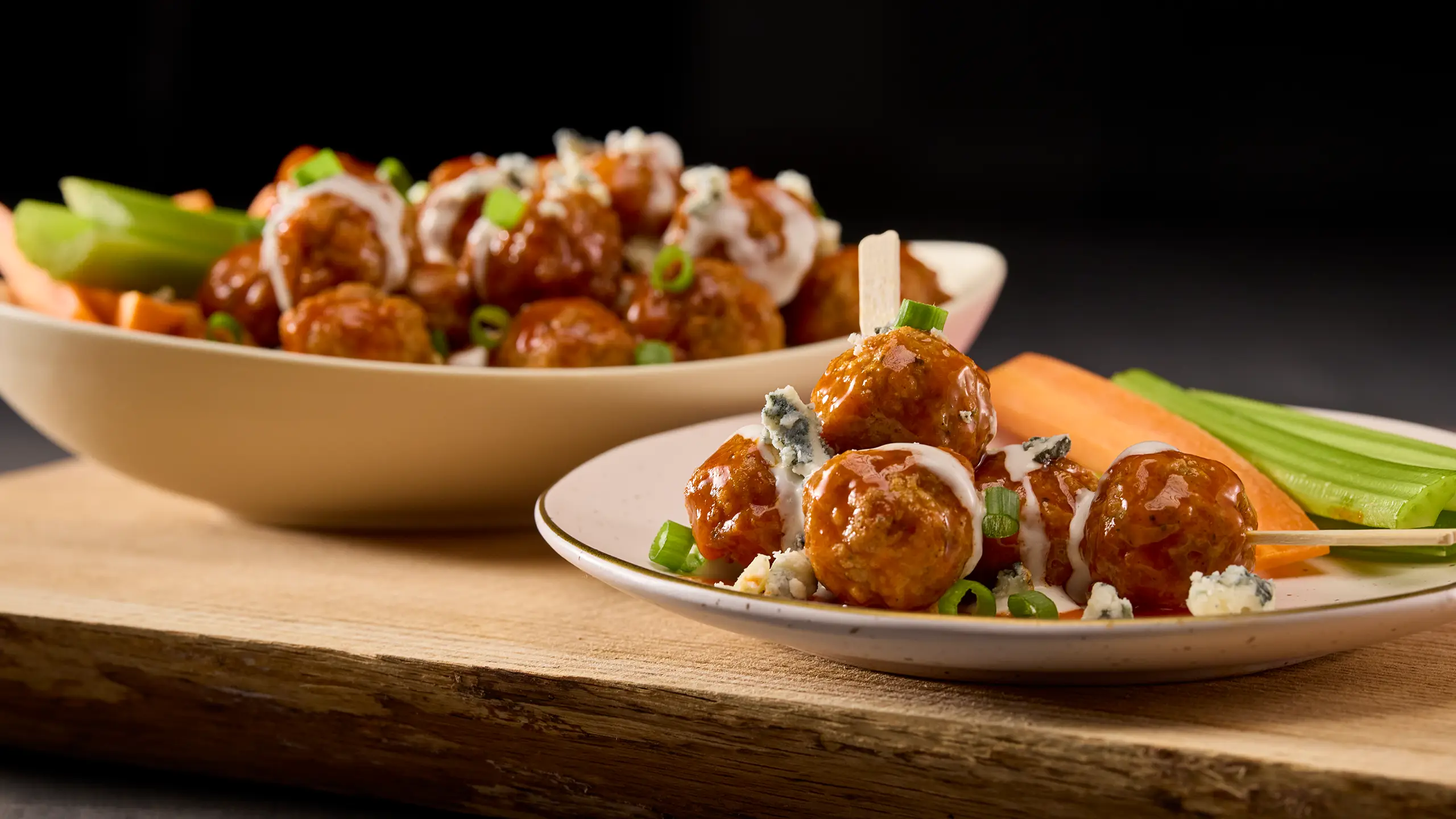 Jones Dairy Farm meatballs tossed in buffalo sauce with blue cheese, green onions, carrots, and celery