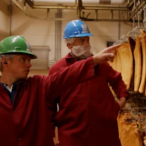 Jones Dairy Farm employees inspecting dry aged bacon in the aging room at the Fort Atkinson production facility