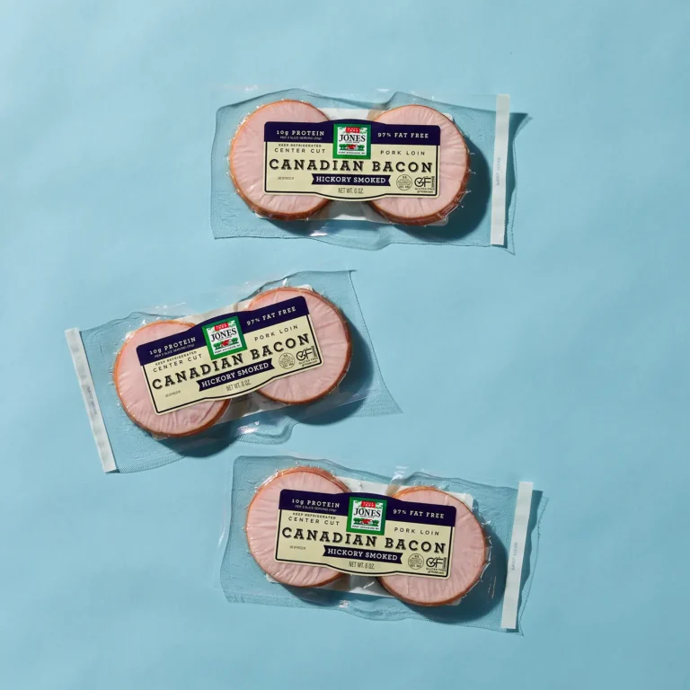 Three packages of Jones Hickory Smoked Canadian Bacon Slices on a blue background