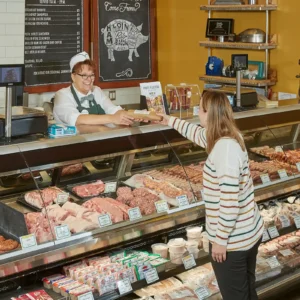 Jones Dairy Farm employee serving a customer at the Jones Market deli counter