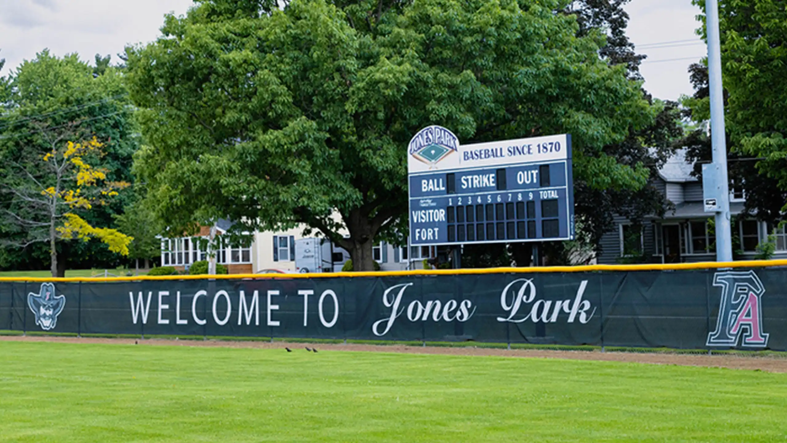Jones Park baseball field in Fort Atkinson, Wisconsin with outfield wall signage and scoreboard