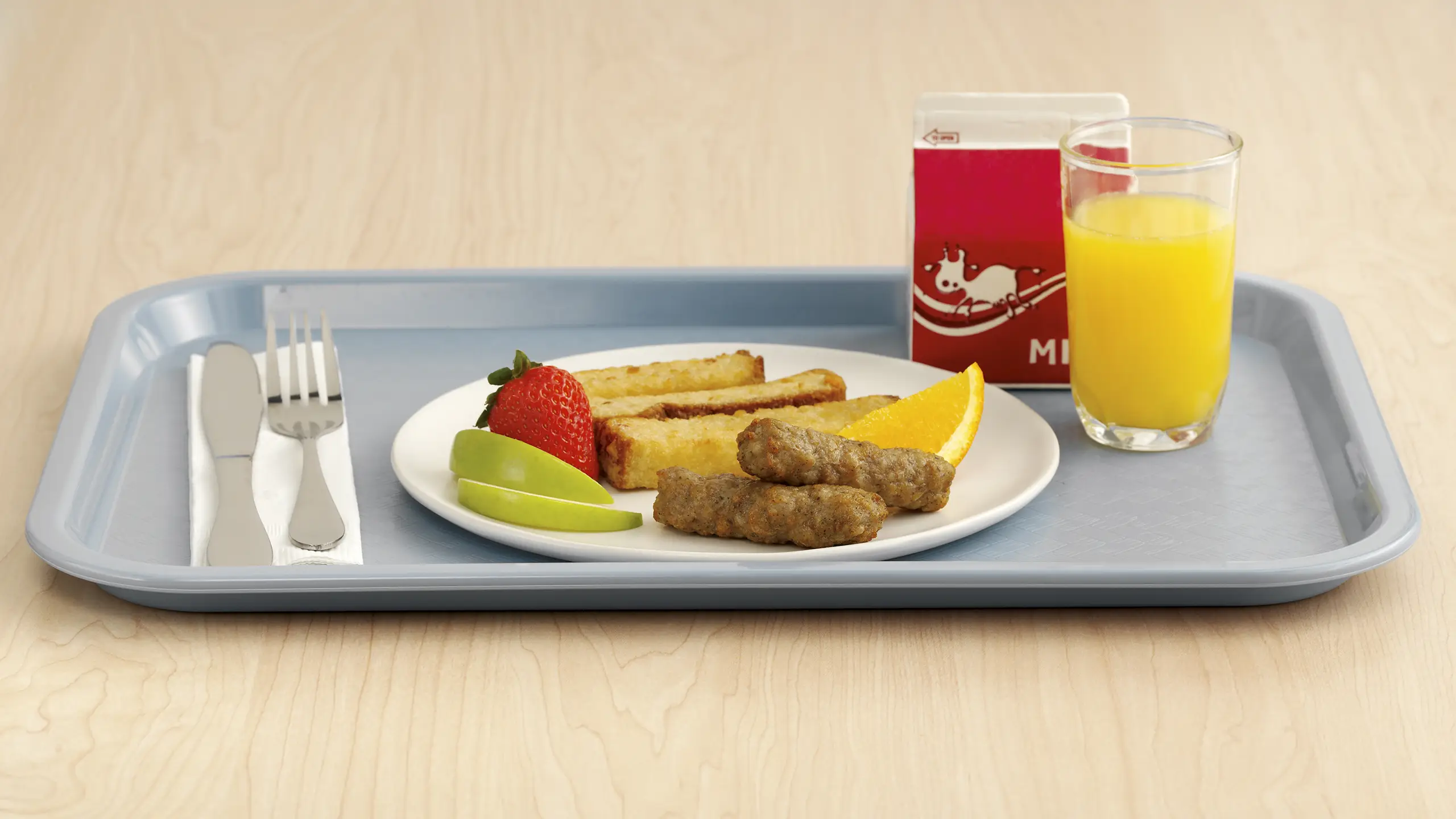 Jones Dairy Farm sausage links on a K-12 school breakfast tray with French toast sticks, fresh fruit, milk, and orange juice