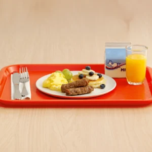 Jones Dairy Farm sausage links with scrambled eggs, pancakes, fresh fruit, milk, and orange juice on a school cafeteria tray