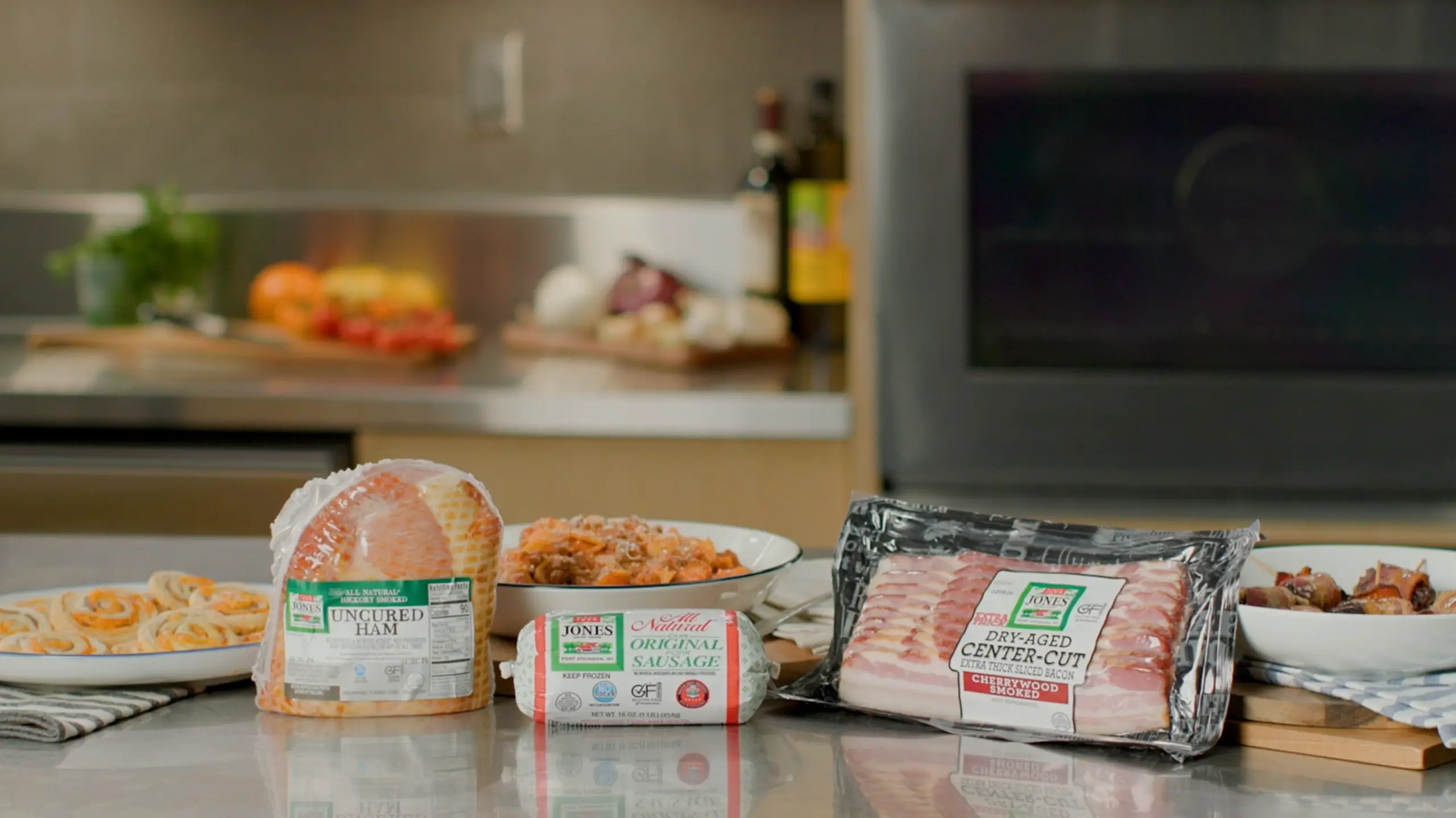 Jones Uncured Ham, Sausage Roll, and Dry Aged Cherrywood Smoked Bacon products on kitchen counter