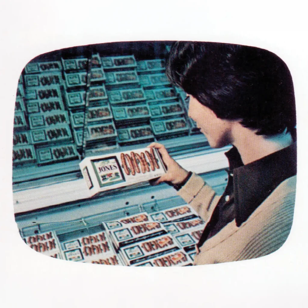 Vintage 1965 Jones Dairy Farm television advertisement still showing a shopper selecting sausage from a grocery store freezer case