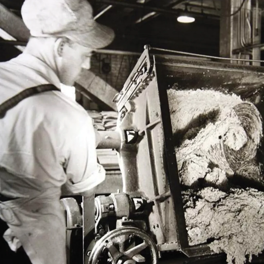 Historic black and white photograph of a Jones Dairy Farm worker operating sausage production equipment circa 1946