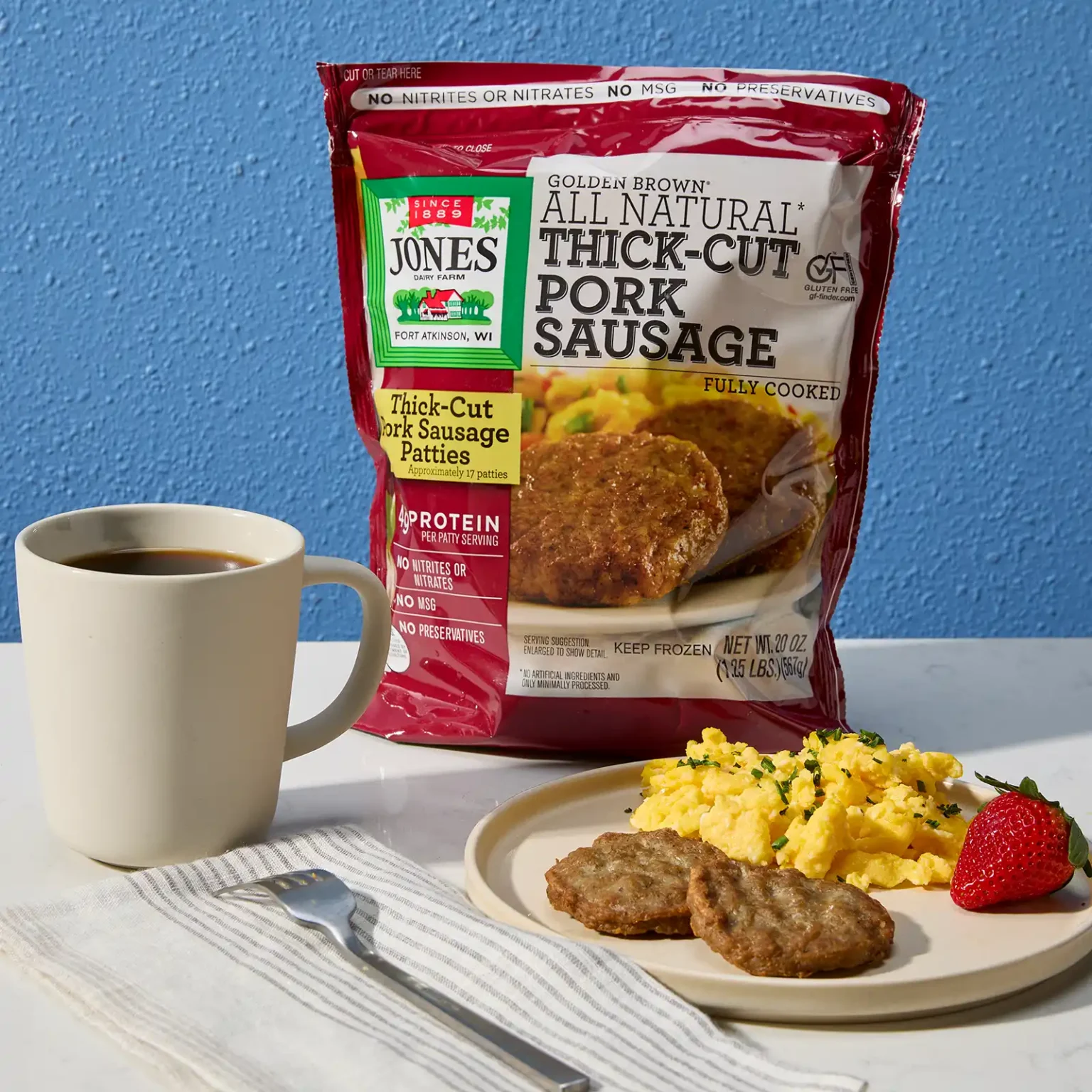 Jones Dairy Farm Golden Brown all natural thick cut pork sausage patties package with a breakfast plate of sausage, scrambled eggs, and fresh strawberry