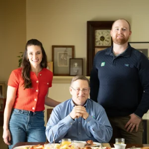 Lisa Caras, Philip Jones, and Will Jones pose together at the family dining table