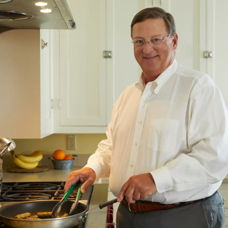 Philip Jones, CEO and Chairman of Jones Dairy Farm, cooking sausage in a skillet