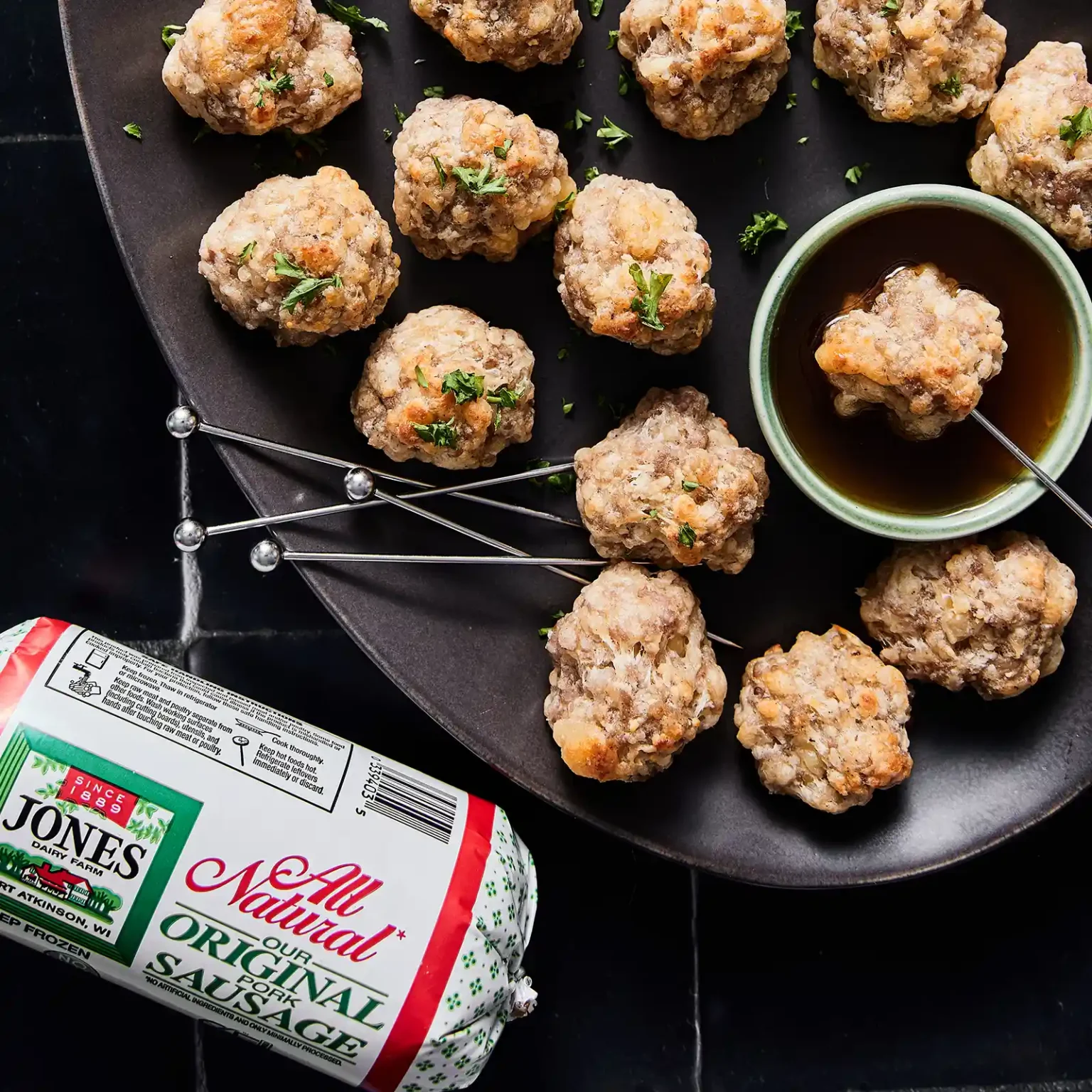 Jones Dairy Farm all natural pork sausage roll package with sausage balls garnished with parsley and a dipping sauce