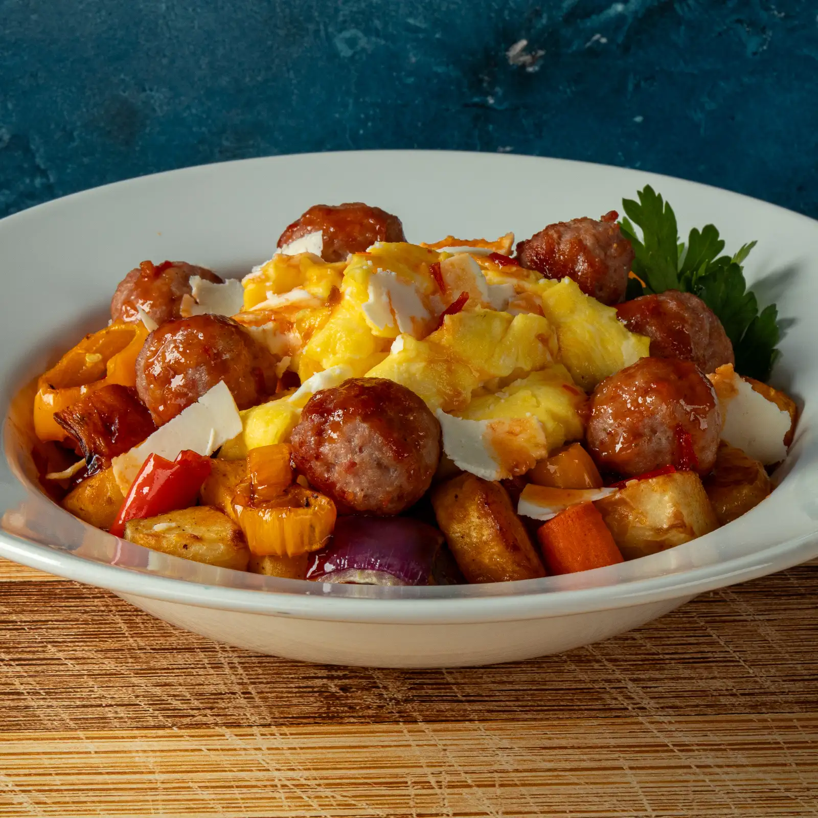 Brunch bowl with roasted root vegetables, scrambled eggs, Jones Dairy Farm pork and bacon meatballs, harissa maple drizzle and shaved Ricotta Salata.