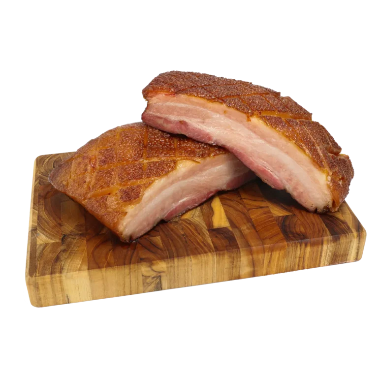 Jones Dairy Farm dry aged bacon slab, scored and sliced to show layers of meat and fat, displayed on a wood cutting board.