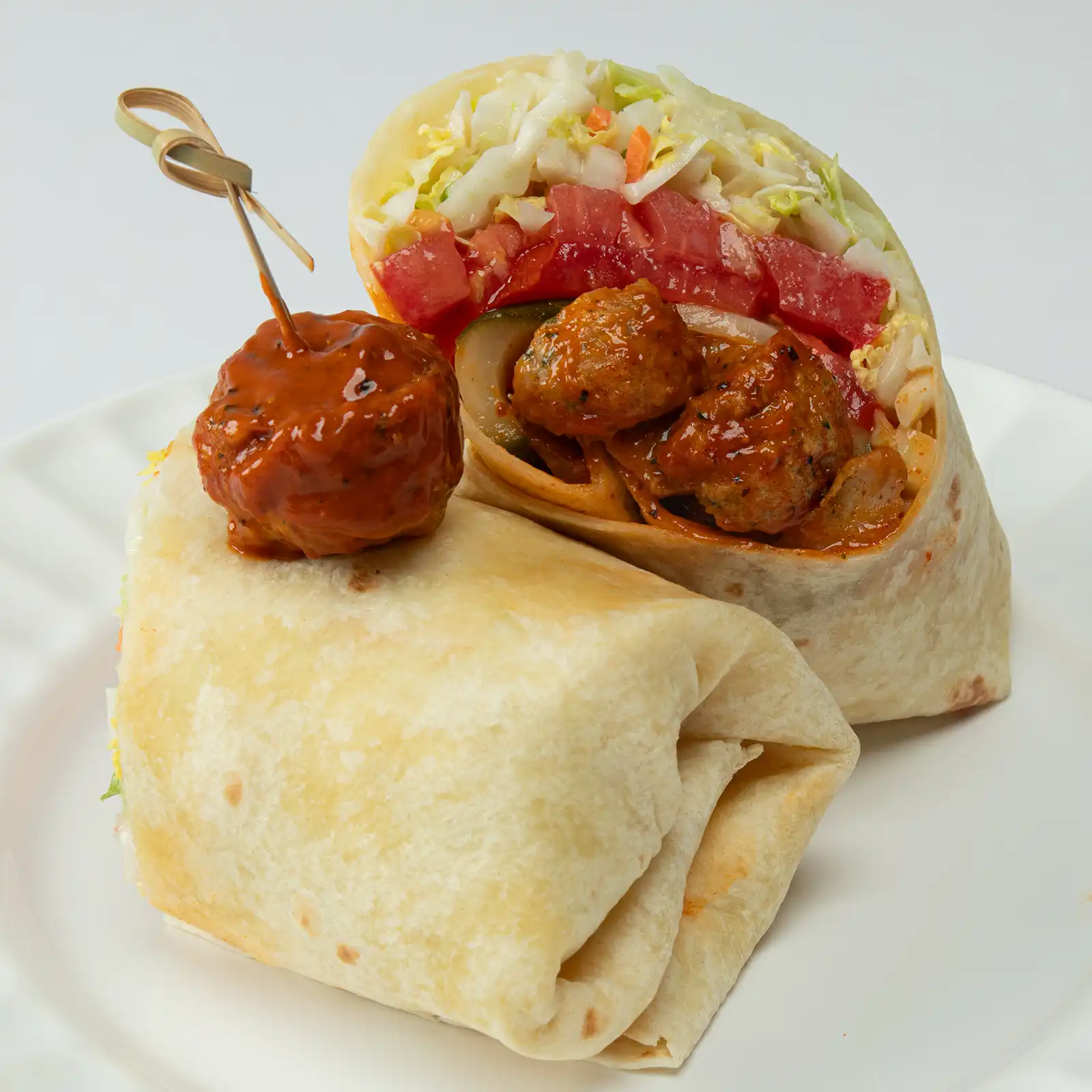 Nashville Hot Meatball Wrap with Jones chicken meatballs in Nashville Hot sauce, Napa cabbage slaw, dill pickles, and heirloom tomatoes in a warm flour tortilla