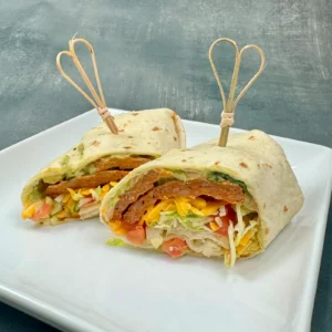 Southwest chicken chorizo burrito wrap sliced in half and served on a white plate, made with Jones Dairy Farm chicken chorizo sausage