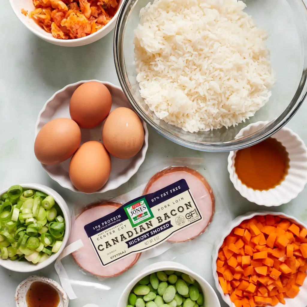 Ingredients for kimchi fried rice with Canadian bacon, including Jones Hickory Smoked Canadian Bacon, cooked rice, eggs, kimchi, carrots, edamame, peas, green onion, soy sauce, and fish sauce.