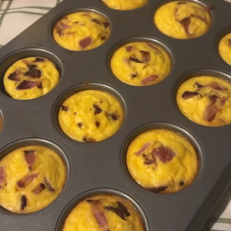 Baked bacon and tater tot egg bites in a muffin tin, golden and set.