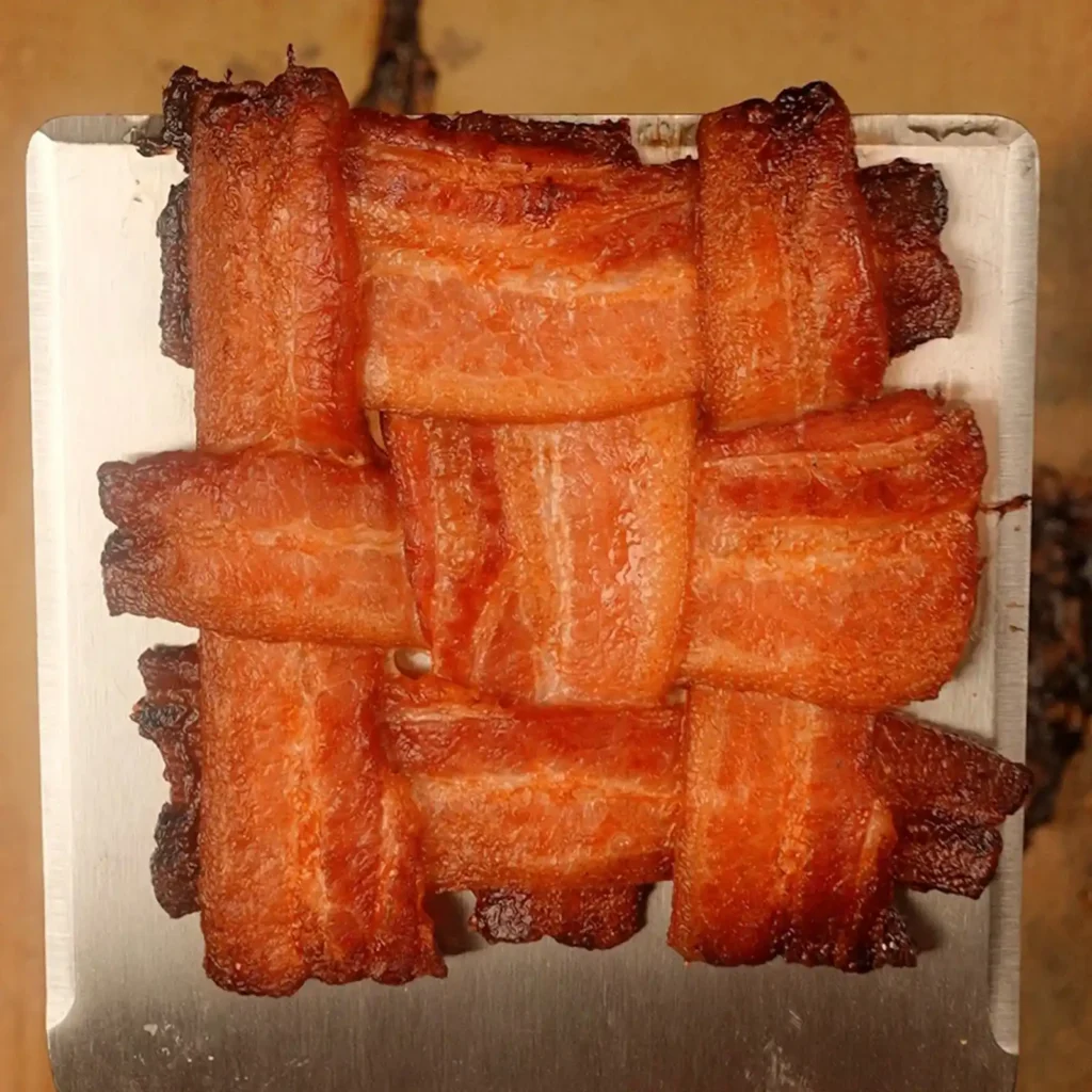 Crispy, golden-brown bacon weave resting on a metal spatula
