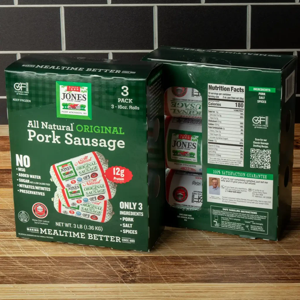 Front and back of a Jones All Natural Original Pork Sausage 3-pack box on a wooden surface, showing the “only 3 ingredients” callout of pork, salt, and spices, plus the nutrition facts panel.